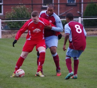 Yorkshire Amateur striker Craig Heard holds the ball up as Sam Jerome holds onto him