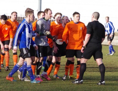 Referee Adrian Holmes gets surrounded after awarding Shaw Lane their second penalty