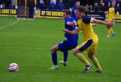 Andy Milne attempts to get in front of Harrogate striker Connor Bower