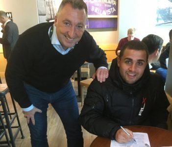 AFC Emley manager Darren Hepworth watches over as Ash Flynn signs his new deal