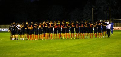 Brighouse players, all wearing top with number five on, observe the minute's silence in memory of Shaw Lane AFC defender Dan Wilkinson